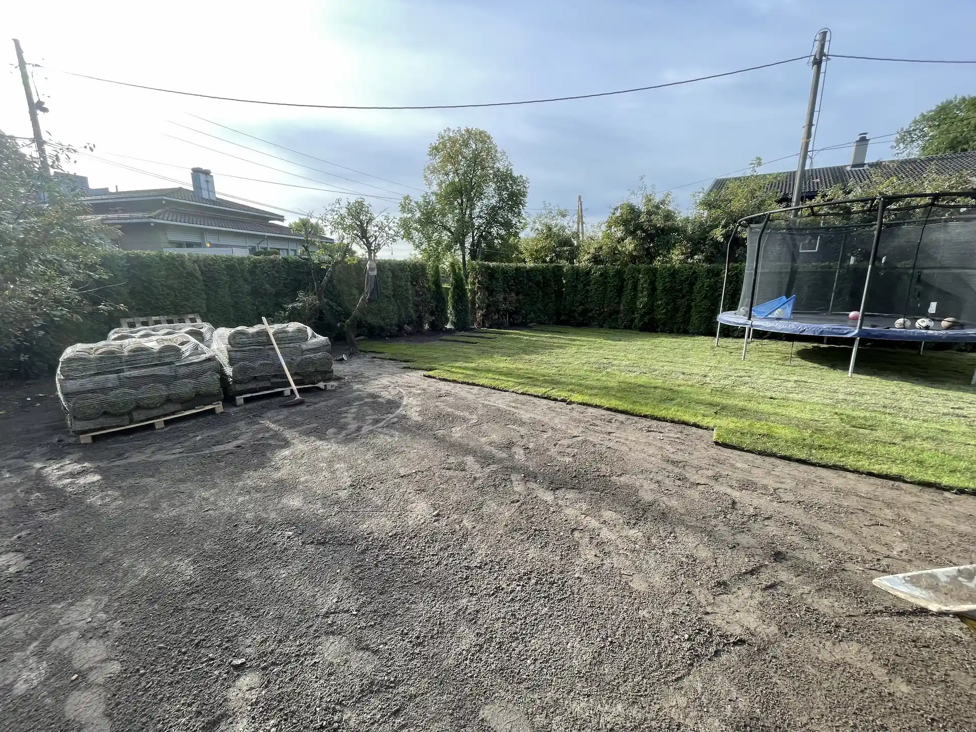 Legging av ferdigplen i en norsk hage med hekk og trampoline